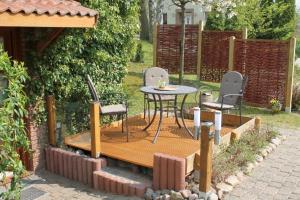 a patio with a table and chairs in a backyard at Ostseeoase in Ratekau