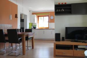 cocina y sala de estar con mesa y TV en Ostseeoase, en Ratekau