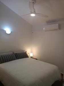 sypialnia z białym łóżkiem i wentylatorem sufitowym w obiekcie toni's apartament Menorca w mieście Cala'n Bosch
