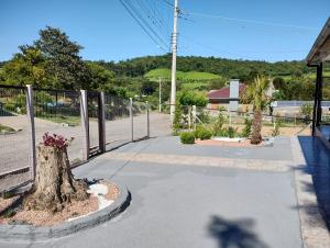 a walkway with a fence and a tree at Pousada Somenzi in Bento Gonçalves