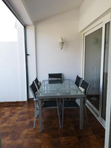 mesa de comedor con sillas y ordenador portátil en toni's apartament Menorca en Cala'n Bosch