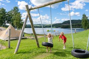 two children playing on a tire swing at a park at Topcamp Mjøsa - Brumunddal in Brumunddalen