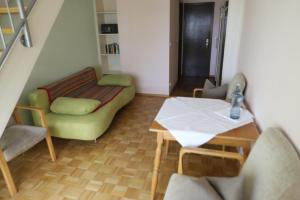 uma sala de estar com um sofá verde e uma mesa em Gasthof - Pension Krämerhof em Thanstein