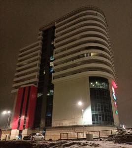 a tall building with a car parked in front of it at Panorama Apartament Plaza Tower in Satu Mare