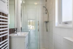 een witte badkamer met een douche en een wastafel bij Topcamp Mjøsa - Brumunddal in Brumunddalen