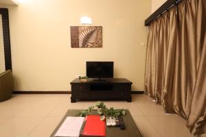 a living room with a television and a table at TOP 1 family trip relax resort in melaka pecuma water park tiket in Malacca