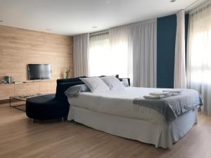 a bedroom with a large bed and a chair at Al_reparo Home Beach _ Adra in Adra
