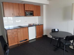 a small kitchen with a table and a microwave at Parramatta Hotel Apartment in Sydney