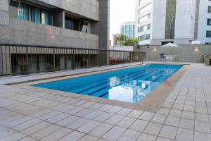 uma piscina ao lado de um edifício em Suíte na Savassi, fique perto de tudo! em Belo Horizonte
