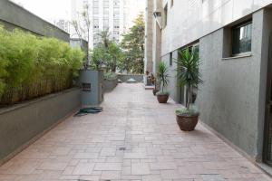 um corredor vazio com vasos de plantas ao lado de um edifício em Suíte na Savassi, fique perto de tudo! em Belo Horizonte