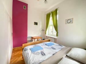 1 dormitorio con cama y pared púrpura en Oliwka Hostel, en Varsovia