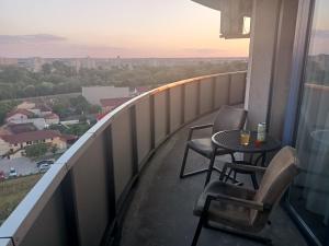 Un balcón con 2 sillas y una mesa con vistas. en Panorama Apartament Plaza Tower, en Satu Mare