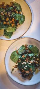 dos platos de comida con espinacas y nueces en una mesa en Le Bezy Pyrénées, en Mézerville