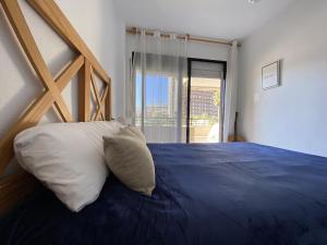 ein Schlafzimmer mit einem großen Bett und einem großen Fenster in der Unterkunft A28 - Frontmar - 2004 Finestrat s.l. in Cala de Finestrat