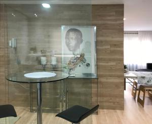 a glass table in a room with a picture of a man at Al_reparo Home Beach _ Adra in Adra