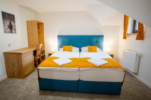 a bedroom with a blue and white bed with yellow pillows at Rezort pri jazere Podbanské in Pribylina