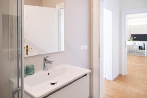 ein weißes Badezimmer mit einem Waschbecken und einem Spiegel in der Unterkunft Italyescapes Emma 11 in Meran