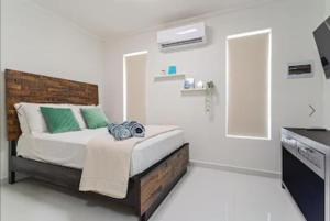 a bedroom with a bed with green and white pillows at Bida Marino Residence Aruba in Palm-Eagle Beach