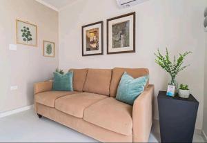 a living room with a brown couch with blue pillows at Bida Marino Residence Aruba in Palm-Eagle Beach +49 photos