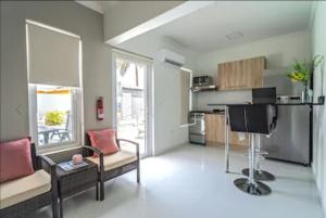 Bida Marino Residence Aruba في شاطئ بالم إيغل: غرفة معيشة مع كرسيين ومطبخ