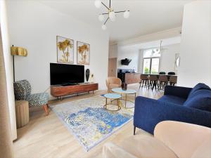 sala de estar con sofá azul y TV en Hypercentre, quai de Loire, lumineux, spacieux, familial, le Jehan de Saveuse, en Blois
