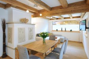 a dining room with a wooden table and chairs at UR-NATUR Appartements in Maria Alm am Steinernen Meer