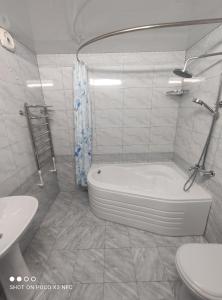 a white bathroom with a tub and a sink at Khiva Tosh Darvoza in Khiva