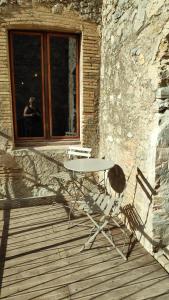 une table et une chaise assises sur une terrasse en bois dans l'établissement Mas Del Llop Blanc - Dog friendly Hostal Rural - B&B, à Sobrestany