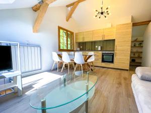 uma sala de estar com uma mesa de vidro e cadeiras brancas em Sweet & Cosy Chalet in the heart of the Swiss Alps em Troistorrents