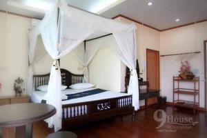 a bedroom with a large bed with a canopy at 9 เฮ้าส์ เชียงคาน in Chiang Khan