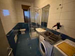 La salle de bains est pourvue d'un lavabo et d'un lave-linge. dans l'établissement A Casa Di Laura B&B Apartments, à Campagna