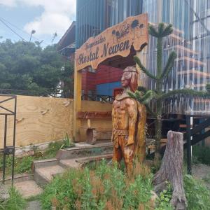 a statue of a man in front of a building at Hostal Newen in Villarrica