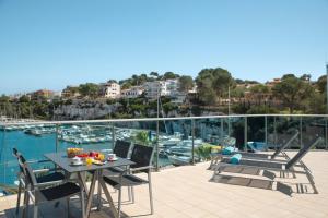 a balcony with a table and chairs and a view of a marina at Porto Drach Aparthotel & Suites in Porto Cristo