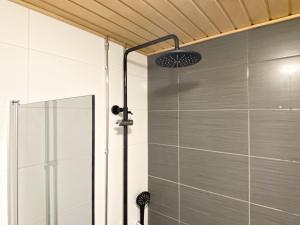 a shower with a glass door in a bathroom at Tammer Huoneistot - City Suite 2 - City View & Perfect location in Tampere