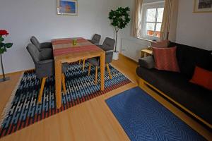 salon ze stołem, krzesłami i kanapą w obiekcie Appartemens Marianne w mieście Grossgmain