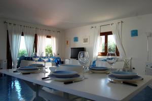 una mesa con platos y copas de vino. en Villa Smeralda, en Palau