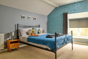 Finest Retreats - Bodlawen Holiday House - Edge of Snowdonia في Cerrig-y-Druidion: غرفة نوم بسرير مع جدار ازرق