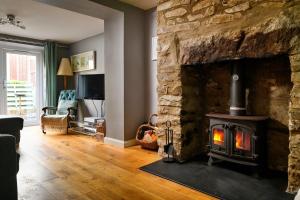 a living room with a stone fireplace with a stove at Finest Retreats - Bodlawen Holiday House - Edge of Snowdonia in Cerrig-y-Druidion