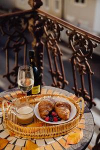 a table with a plate of pastries and a glass of wine at ARTELIER - Trenčianske Teplice in Trenčianske Teplice