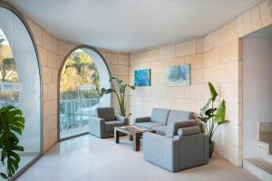 a living room with two chairs and a table at Porto Drach Aparthotel & Suites in Porto Cristo