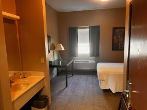 a hotel room with a bed and a sink at Ambridge Inn in Ambridge