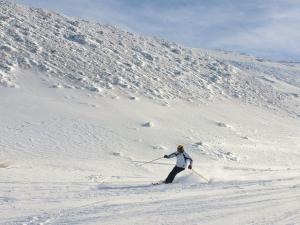 a man is skiing down a snow covered slope at Apartamentos Sierra Nevada 3000 in Sierra Nevada