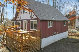 a red tiny house with a wooden fence at Arrowhead Lake Leisure in Pocono Lake