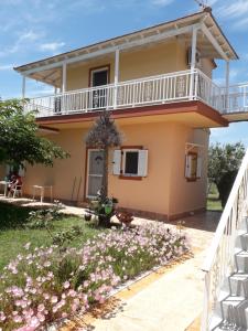 a house with a balcony and flowers at Kampas studios in Agios Georgios