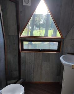 a small bathroom with a window and a toilet at Domo Las araucarias in Negrete