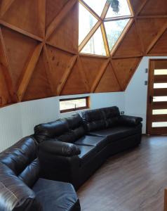 un sofá de cuero en una sala de estar con techo en Domo Las araucarias, en Negrete