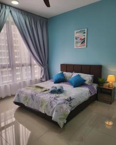 a bedroom with a bed with two blue pillows at Bali Residence Impian Raudah in Melaka