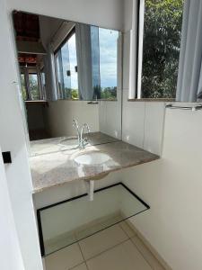 a bathroom with a sink and a mirror at Hostel Pipe House in Ilhéus