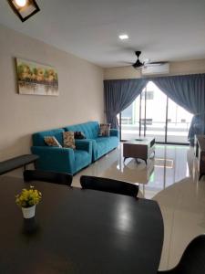 a living room with a blue couch and a table at KH Water Park Manhattan Condo Ipoh Homestay in Kampong Pinji