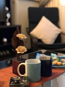 einen Tisch mit zwei Kaffeetassen und eine Vase mit Blumen in der Unterkunft Sweet luxury in Thessaloniki